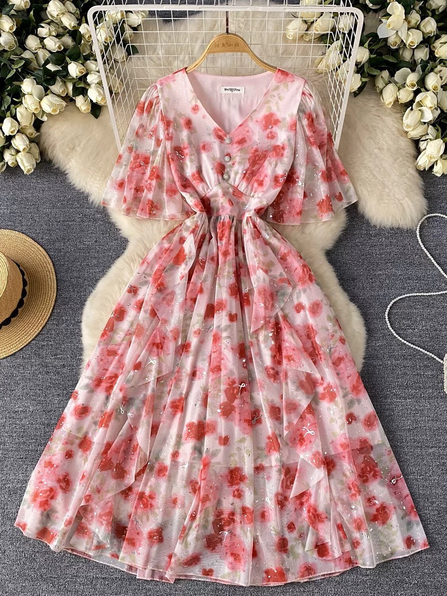Full-length view of the Rosalie Bloom Organza Midi Dress featuring a soft pink floral print, cinched waist, flutter sleeves, and feminine midi-length silhouette.