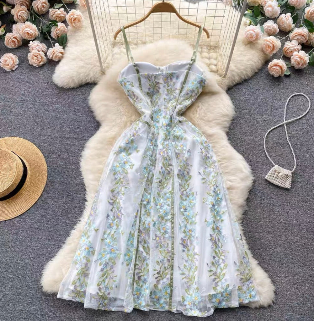 Elegant embroidered corset dress with blue floral pattern and flowing midi-length skirt